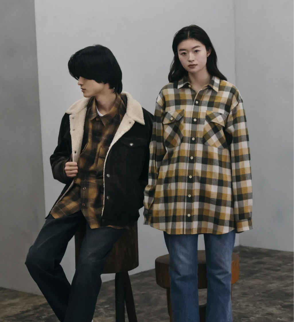 tablet phone グレーのジャケットを着た男女がカジュアルなポーズをとるシーン。