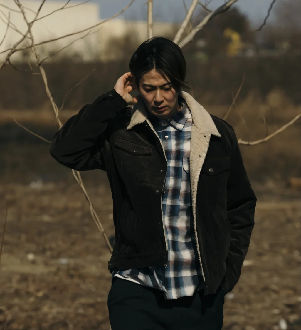 tablet phone グレーのジャケットを着た男女がカジュアルなポーズをとるシーン。