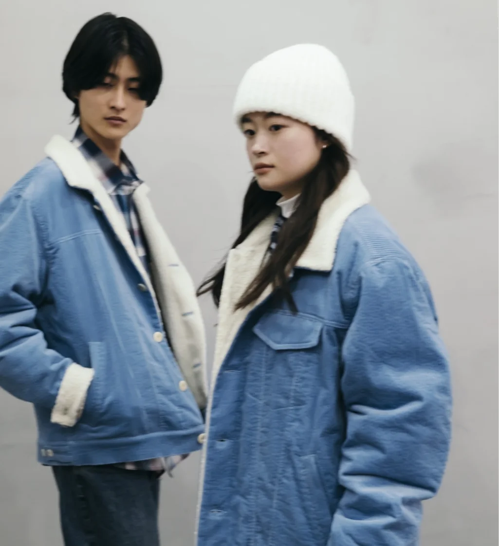 tablet phone グレーのジャケットを着た男女がカジュアルなポーズをとるシーン。